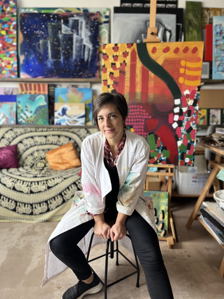 L'artiste peintre professionnelle Sandrine Sueur alias Arasu dans son atelier au Pays Basque, entourée de ses toiles.